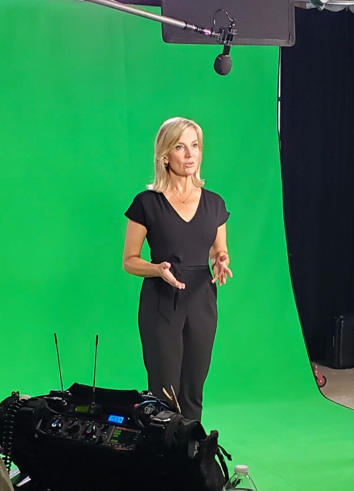 Woman being filmed with green screen background